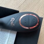 Zbliżenie uchwytu Carli z panelem przycisków, obok instrukcja i czarny woreczek