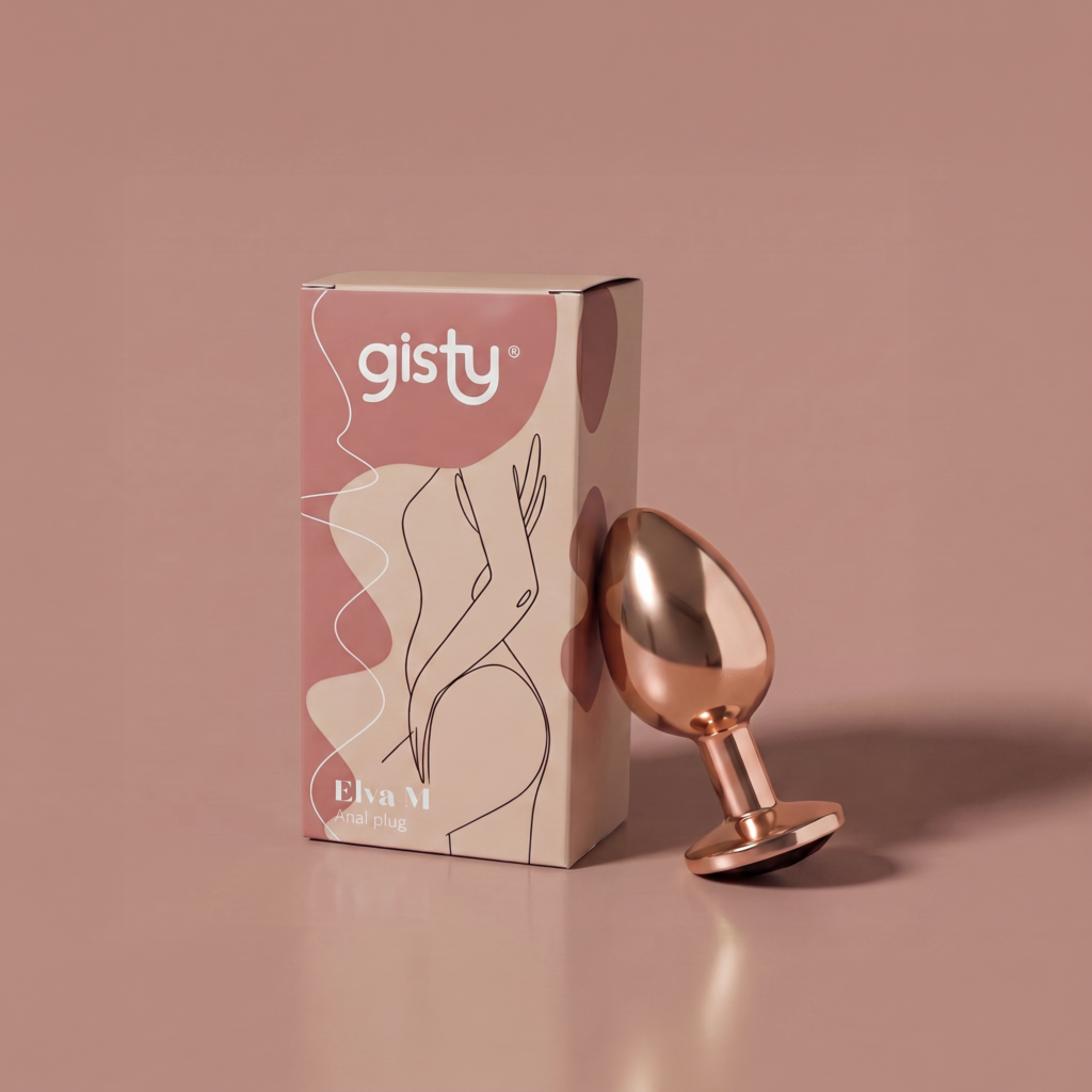 Elva M — metalowy korek analny w kolorze rose gold, widok z boku, obok pudełko gisty