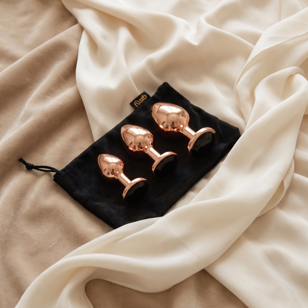 Trzy korki analne Elva w rose gold na czarnym woreczku gisty